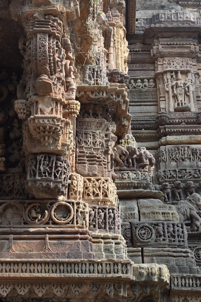 Services Detailed view of intricate stone carvings on the exterior walls of an ancient temple, showcasing artistic craftsmanship.